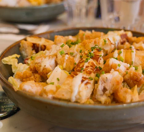 Bol de salade composée avec morceaux de poulet grillé